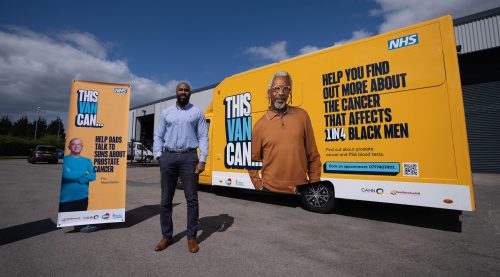 Consultant surgeon Sotonye Tolofari standing in front of ThisVanCan, a mobile NHS prostate cancer clinic.