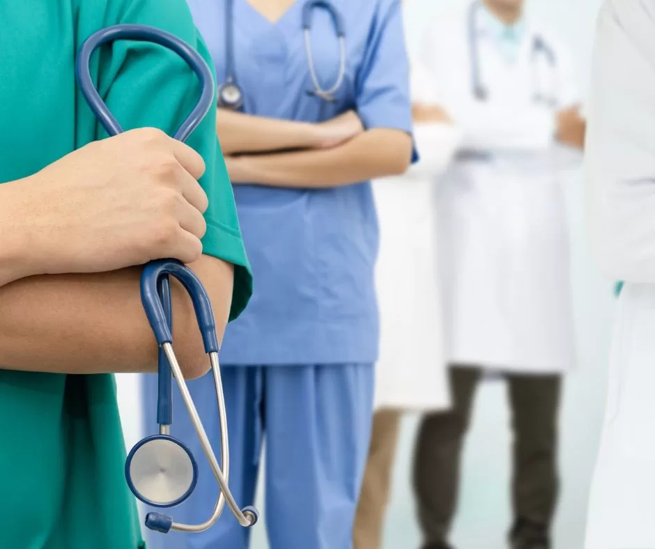 Visual of four doctors, standing behind each other. One is holding a stethoscope.