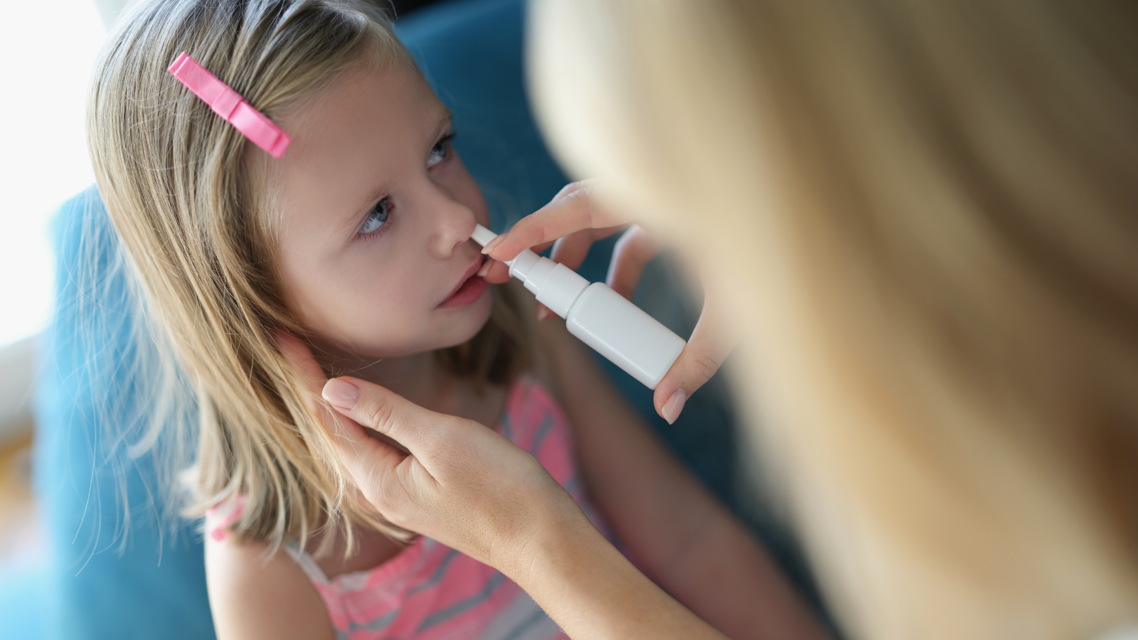 Visual of a young child having a flu nasal spray.