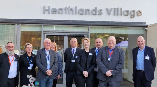 A group of NHS representatives standing outside Heathlands Village assisted living facility