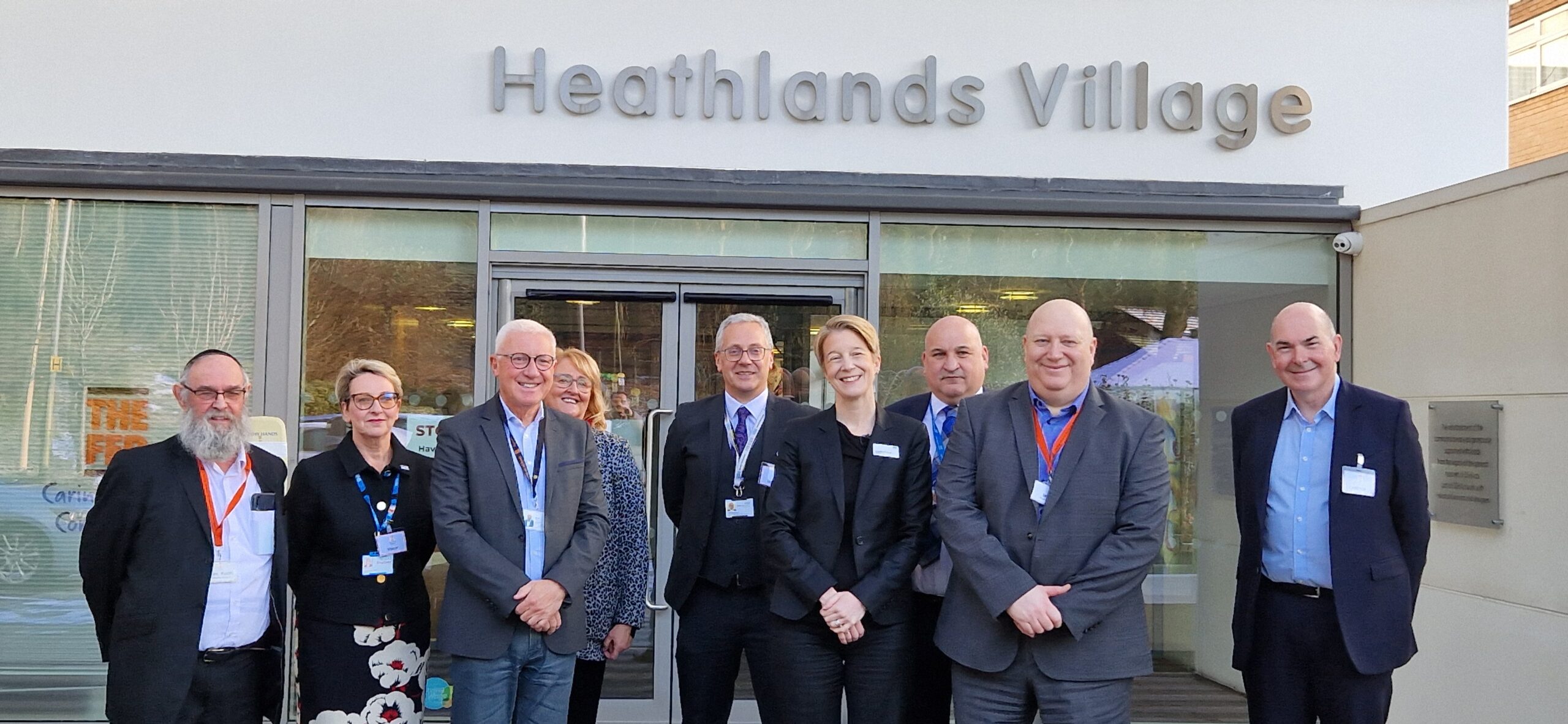 A group of NHS representatives standing outside Heathlands Village assisted living facility