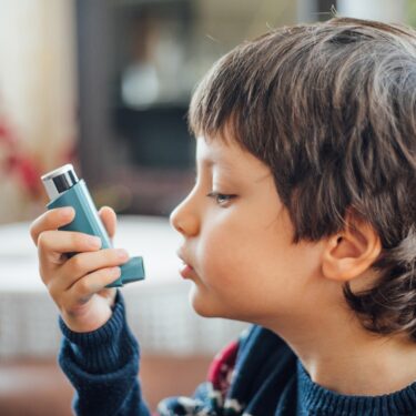 A child using his inhaler.