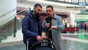 Mike Toolan is having a conversation with a father about GTKWTG in Manchester City Centre.