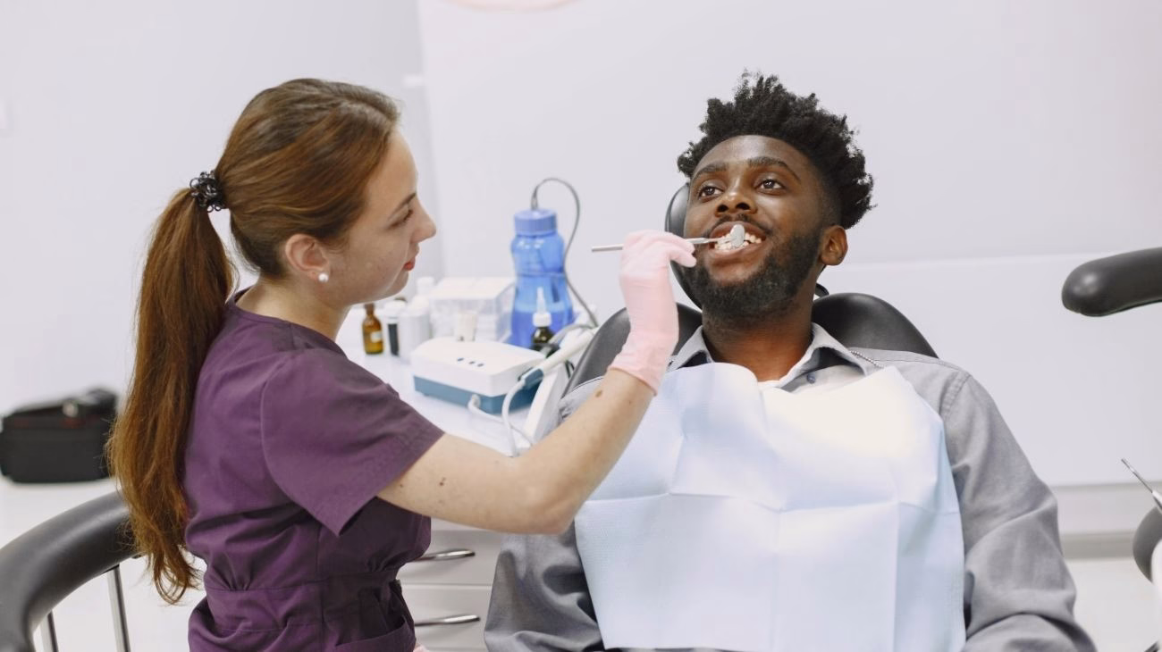 A dentist is examining a patient's teeth in a dental clinic.
