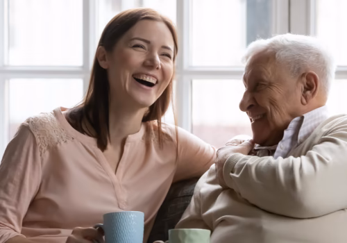 image of two people smiling sat with a cup of tea