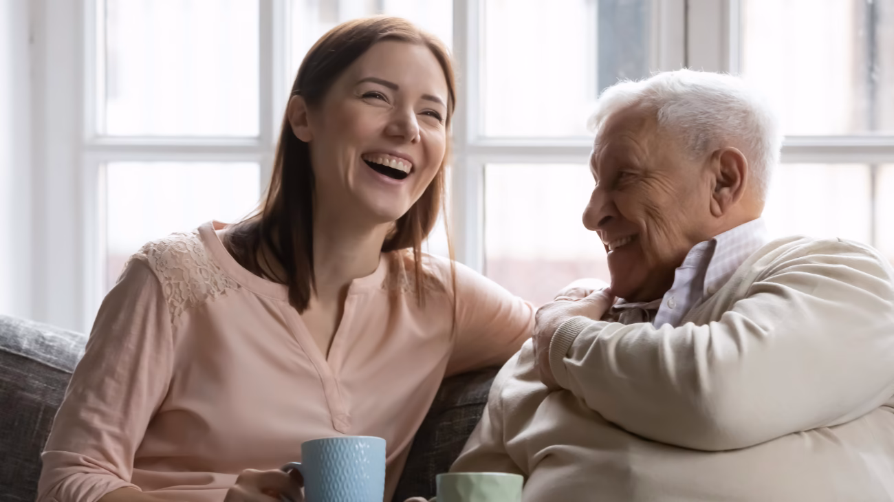 image of two people smiling sat with a cup of tea