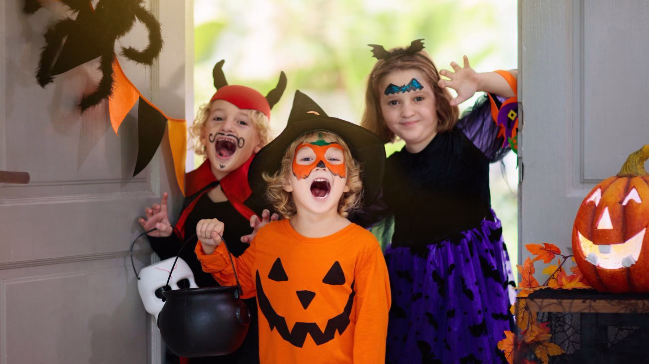 an image of 3 children dressed for Halloween in Halloween outfits, making funny faces to the camera.
