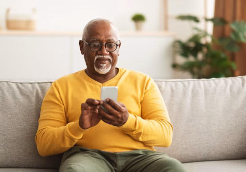 A person sat on a couch using a smartphone