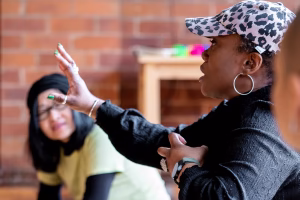 An image of a women talking to other women at a class