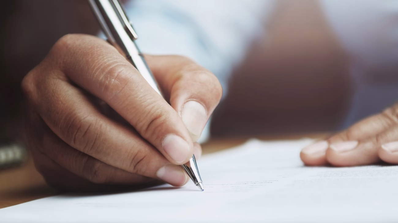A person writing on a piece of paper