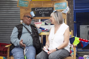 An image of two older people sat together chatting