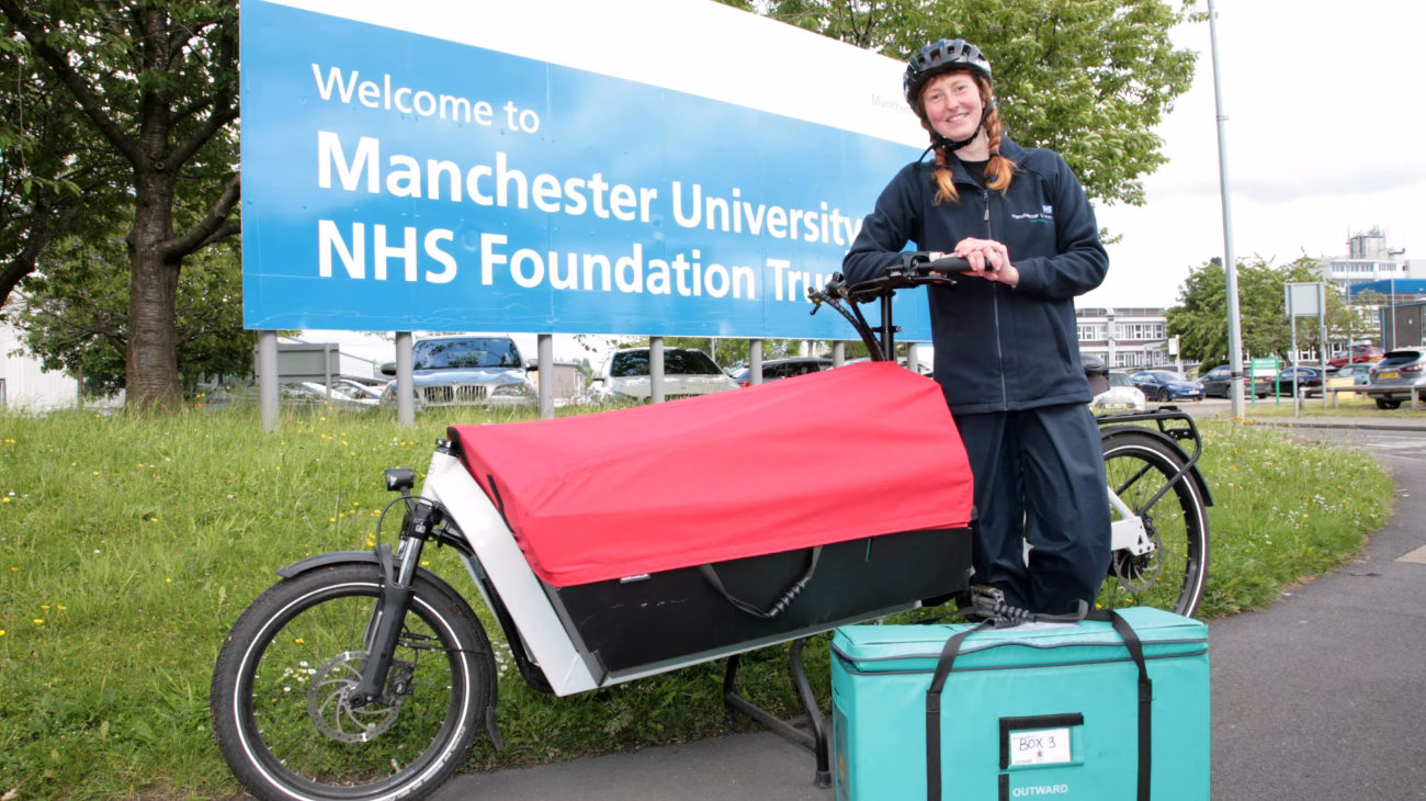 Manchester University NHS Foundation Trust site. A person on a E-cargo bike.