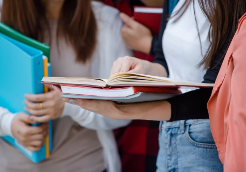 Students holding files and textbooks