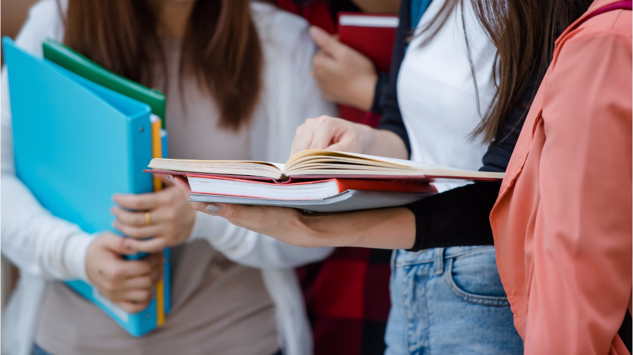 Students holding files and textbooks